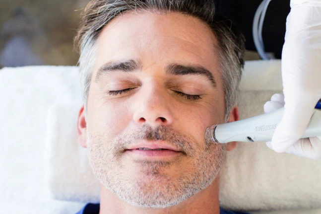 A man receiving a Hydrafacial Deluxe Treatment.